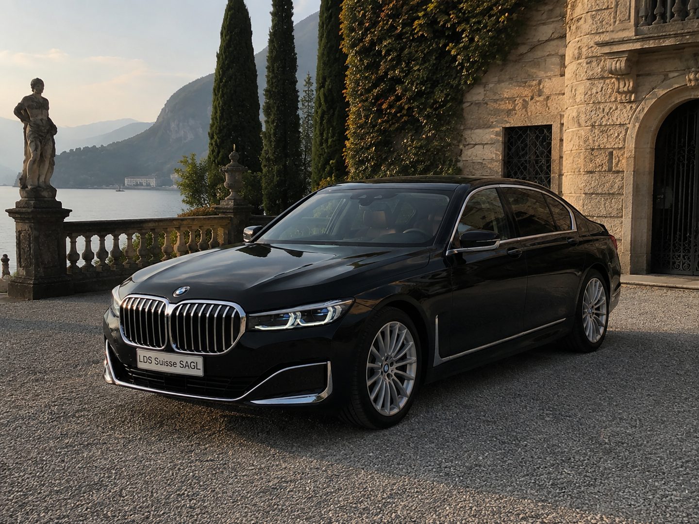 BMW Serie 7 davanti a una villa, fra i cipressi